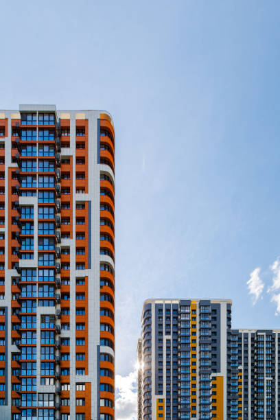 istock freshly built high rise apartment buildings on blue sky background with white clouds 1830502347