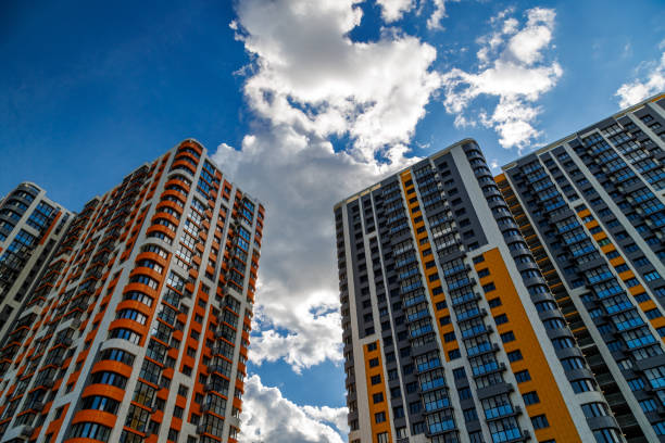 istock freshly built high rise apartment buildings on blue sky background with white clouds 1830502350