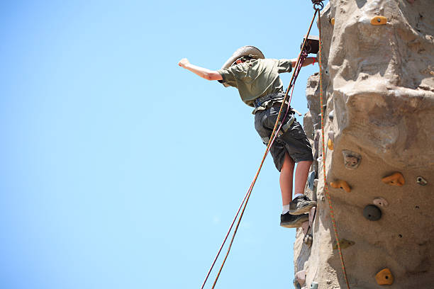 escalada em rocha menino - climbing wall rock climbing holding reaching - fotografias e filmes do acervo