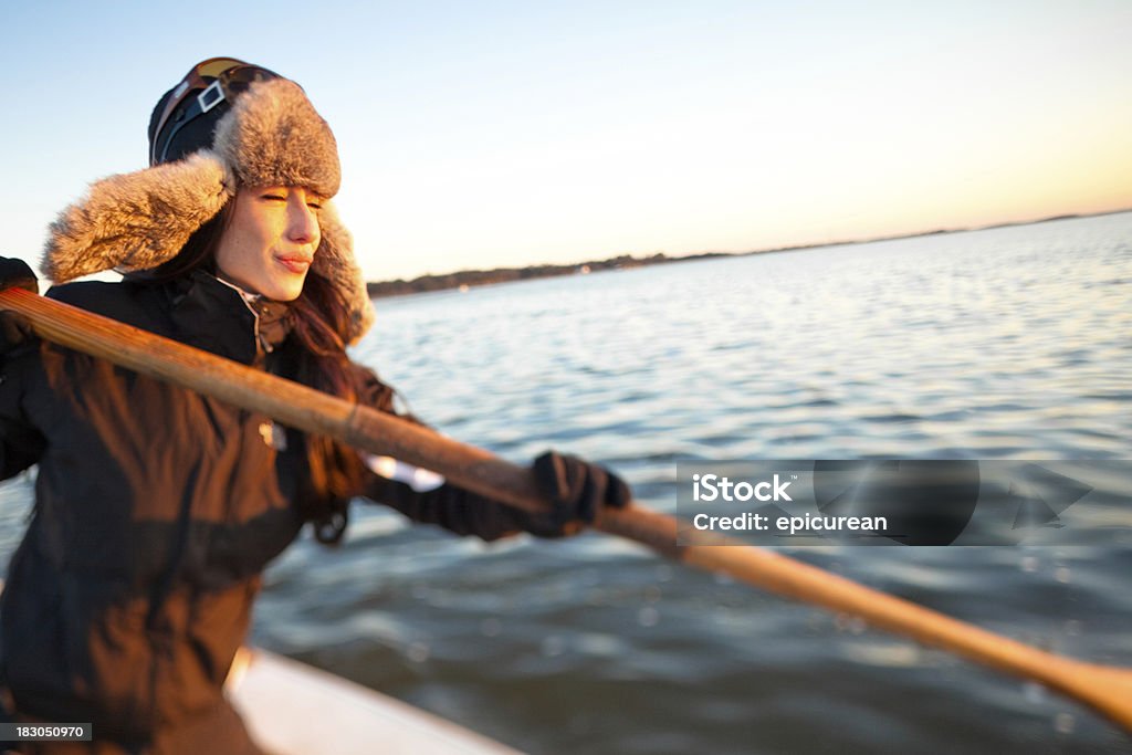 Mujer joven en un barco de remos en invierno - Foto de stock de 20 a 29 años libre de derechos