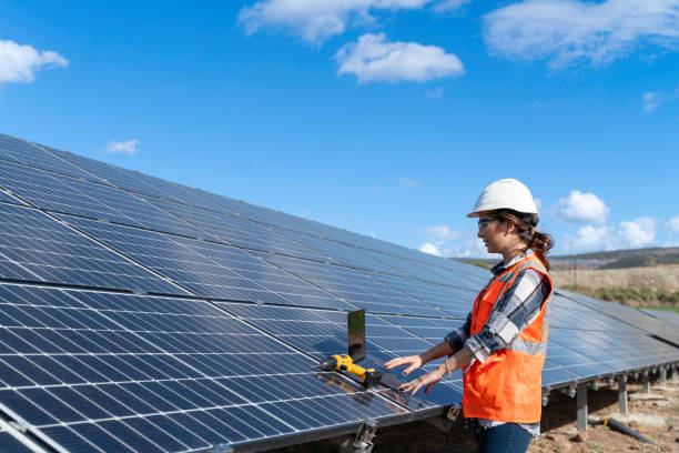 istock Young engineer inspect installation of solar panels installed check  with blueprint on the field, with recording inspection data on pc. 1830514443