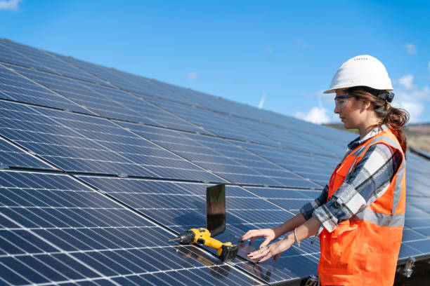 istock Young engineer inspect installation of solar panels installed check  with blueprint on the field, with recording inspection data on pc. 1830514475