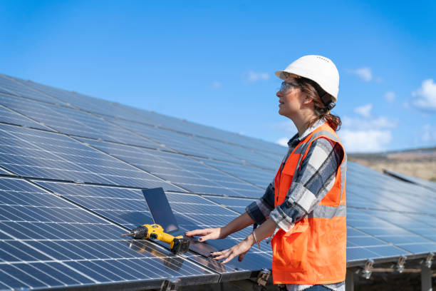 istock Young engineer inspect installation of solar panels installed check  with blueprint on the field, with recording inspection data on pc. 1830514476