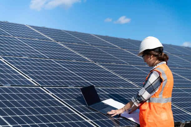 istock Young engineer inspect installation of solar panels installed check  with blueprint on the field, with recording inspection data on pc. 1830514481