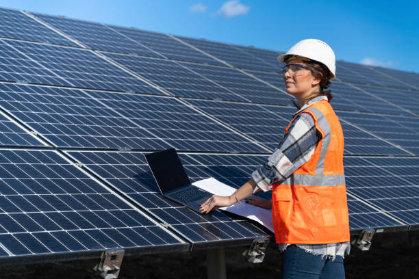 istock Young engineer inspect installation of solar panels installed check  with blueprint on the field, with recording inspection data on pc. 1830515032