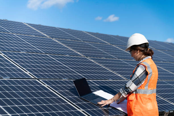 istock Young engineer inspect installation of solar panels installed check  with blueprint on the field, with recording inspection data on pc. 1830515576