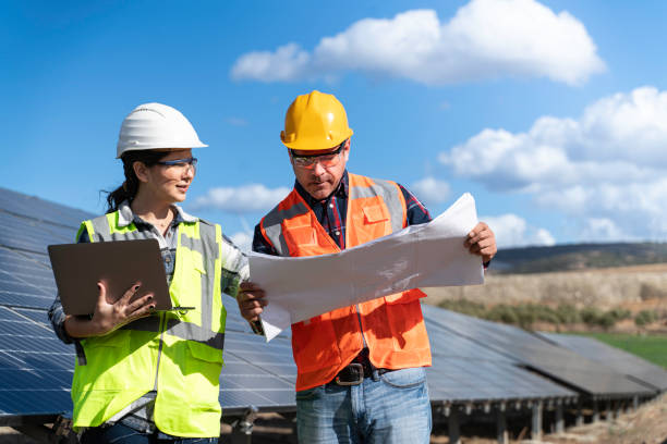 istock Young engineer inspect installation of solar panels installed check  with blueprint on the field, with recording inspection data on pc. 1830517873