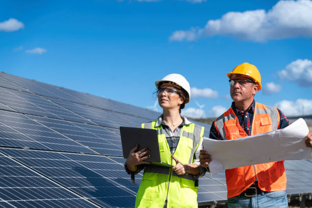 istock Young engineer inspect installation of solar panels installed check  with blueprint on the field, with recording inspection data on pc. 1830519556