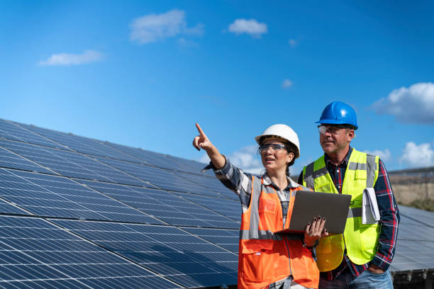 istock Young engineer inspect installation of solar panels installed check  with blueprint on the field, with recording inspection data on pc. 1830519560