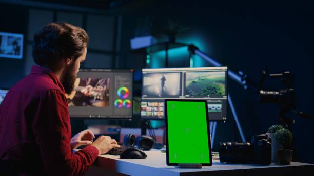 istock Green screen tablet on desk in studio next to video editor arranging recorded stock clips 1830519585