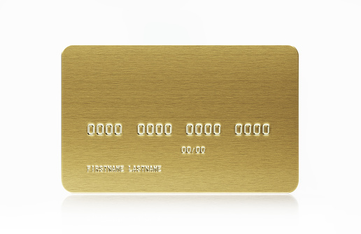 Gold colored credit card on white background. Horizontal composition with copy space.