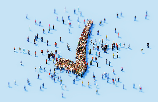 Human crowd forming check mark blue background. Horizontal  composition with copy space.