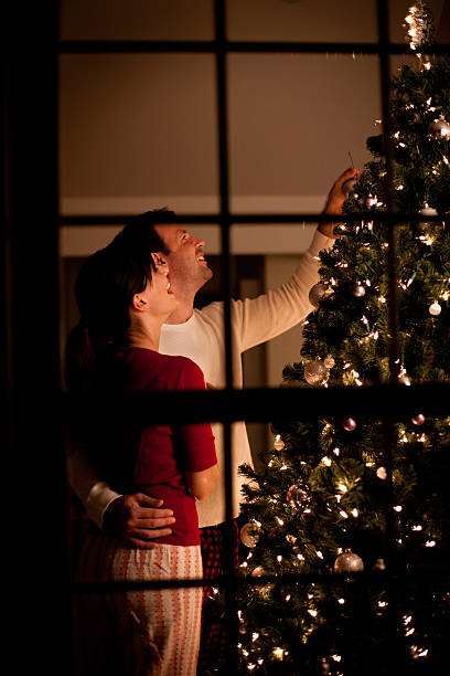 istock Happy Couple Decorating Christmas Tree at Home 183052986