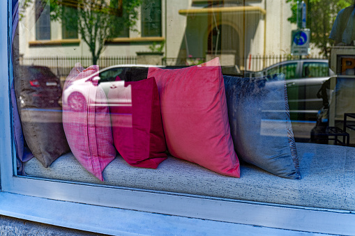 Colorful pillows at shop window of hairdresser at City of Zürich on a sunny summer day. Photo taken July 11th, 2023, Zurich, Switzerland.