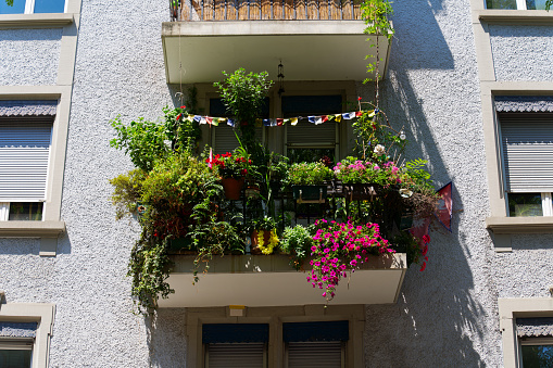 Facade of residential building with beautiful decorated balcony on a hot sunny summer day at Swiss City of Zürich. Photo taken July 11th, 2023, Zurich, Switzerland.