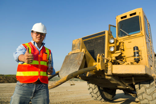 A construction site safety inspector gives the thumbs up.