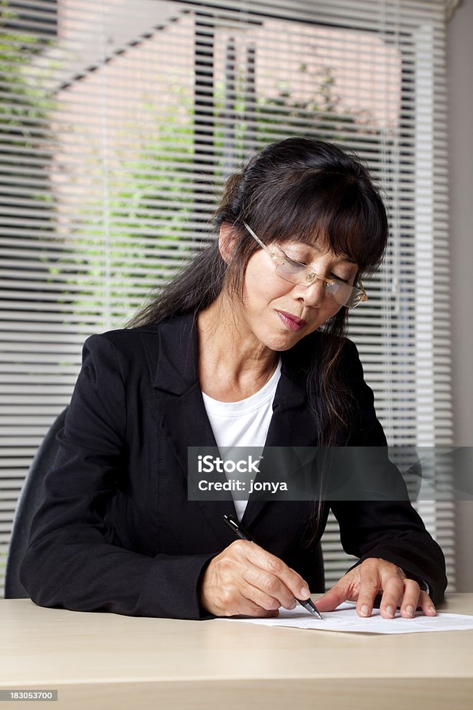 Зрелые Азиатская Деловая женщина подписания договора - Стоковые фото 60-64 года роялти-фри