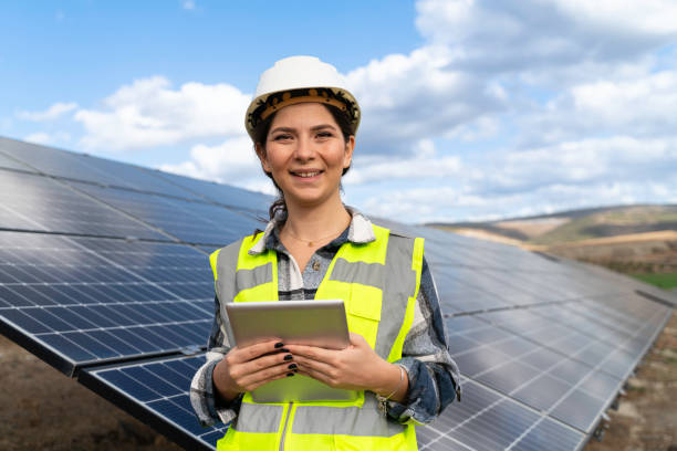 istock Young engineer inspect installation of solar panels installed check  with blueprint on the field, with recording inspection data on pc. 1830538015