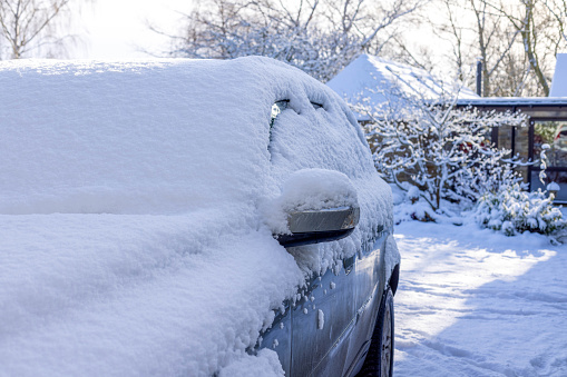 A four-by-four car is in a winter scene. It is covered in snow.
