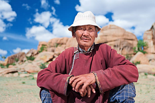 Mongolian man in national clothing, rocks on the backgroundhttp://bem.2be.pl/IS/mongolia_380.jpg
