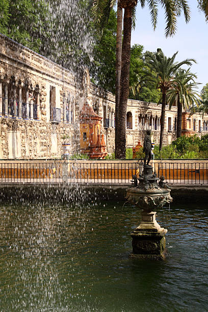 Seville (Sevilla). The Royal Alcazar (Reales Alcazares ). Gardens. "External view of a garden in the Royal Alcazar (Royal Fortress) in Sevilla, Andalucia, Spain.The Royal Alcazar's origin can be situated in the X century, in the era of Abd Al-Rahman, the first Califf of Andalucia, who decided to build it in 913, after a revolt against his government. From then, the fortress underwent several reforms and was theater of numerous historical events. In the XVIII century the royal family of the Borbons stayed here during four years, when the Alcazar lived splendid moments. The Alcazar's Gardens are a world known example of gardening architecture." alcazares reales of sevilla stock pictures, royalty-free photos & images