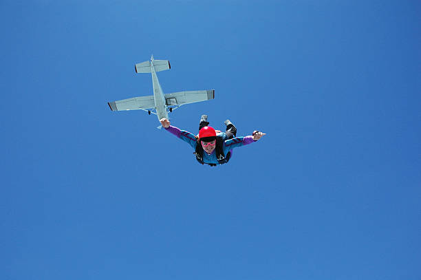 Royalty Free Stock Photo: Happy Woman In Freefall A happy female skydiver in freefall just after jumping out of a Cessna 182. skydiving stock pictures, royalty-free photos & images