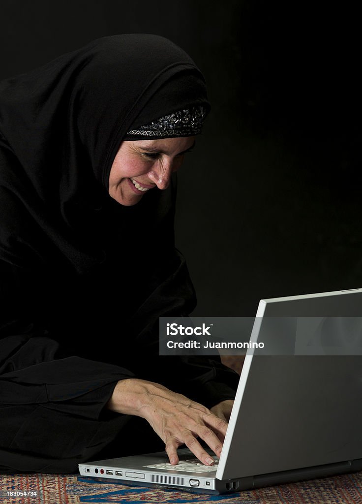中東の女性は彼女のラップトップを使用して - 1人のロイヤリティフリーストックフォト