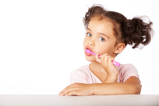 Portrait of a cute girl brushing her teeth.