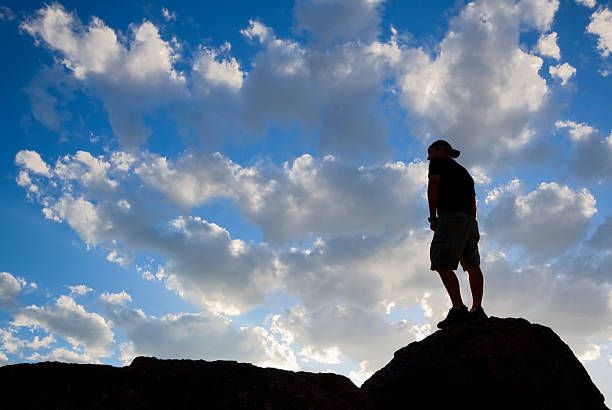 istock silhouette man looking at sunset sky landscape 183054979