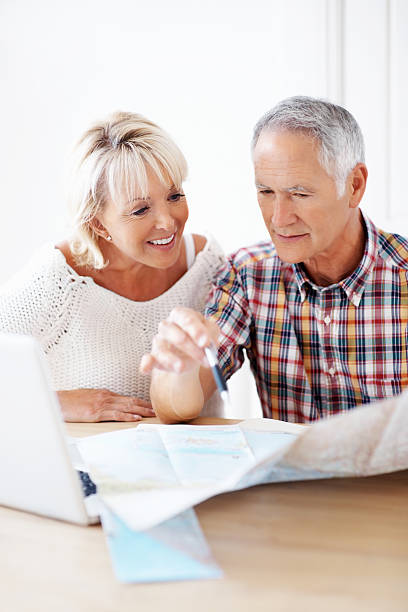 istock Mature woman and man planning vacation with map 183055349