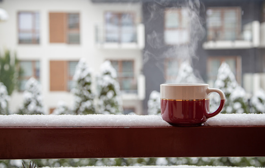 cup of tea in snow on balcony in winter