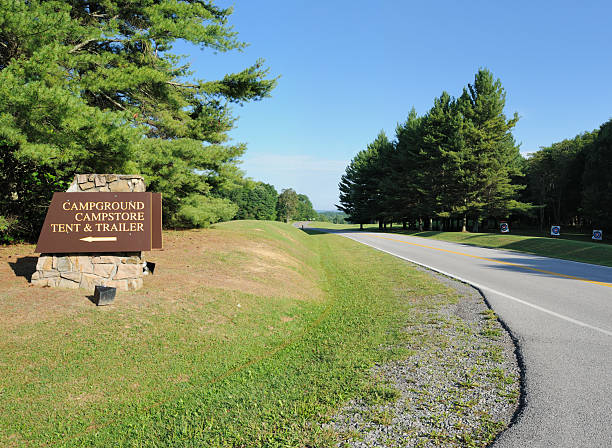 istock Campground campstore tent and trailers sign with road 183055583