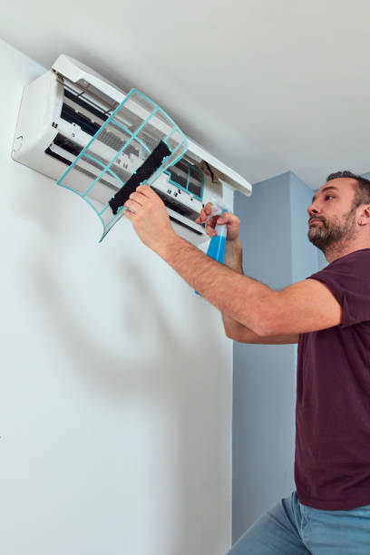 istock Man cleaning and maintaining air condition unit. 1830555884