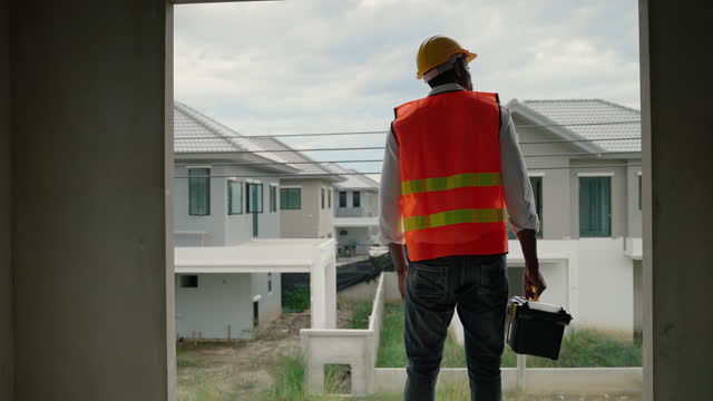 construction foreman is inspecting a building on a housing construction site.