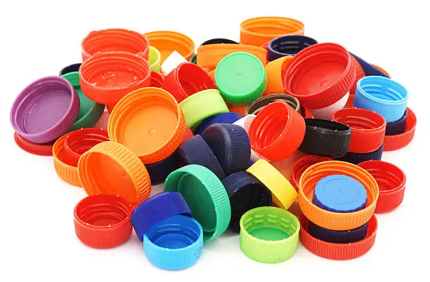 Colorful plastic caps pile isolated in white.