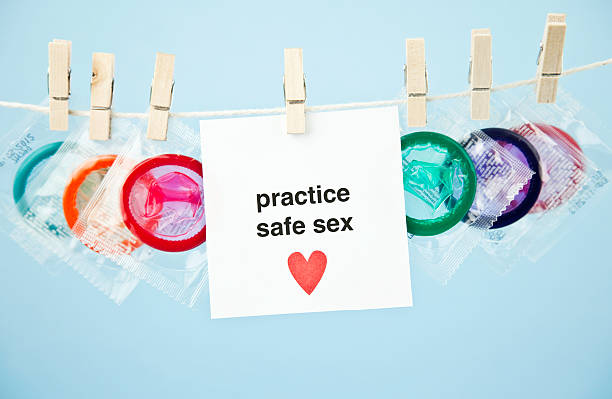Promote Safe Sex Condoms on clothes line with message promoting safe sex. condom photos stock pictures, royalty-free photos & images