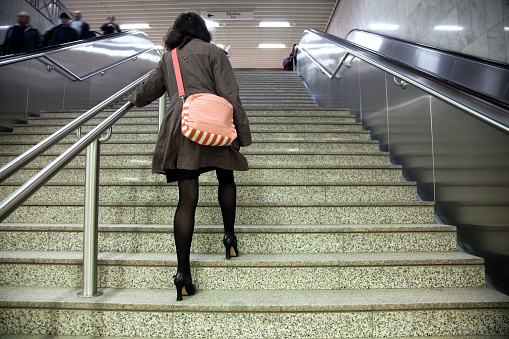 Woman with high heels in the subway stairs. High ISO.