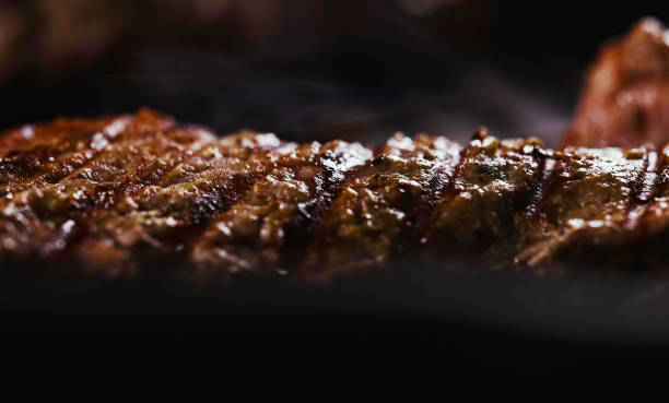 Seasoned tomahawk steak is cooked in a frying pan. stock photo