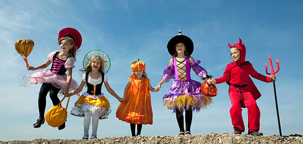 istock Five Halloween Children Jumping at the Blue Sky. 183056629