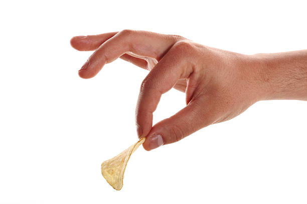 hand picking potato chips stock photo