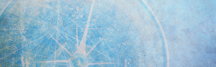 A compass and intersecting lines on a light blue textured surface that provides ample room for copy and text.