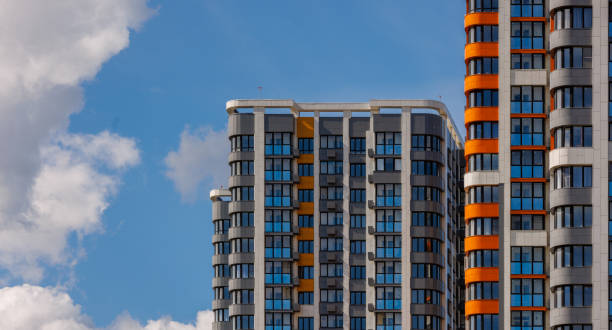 istock freshly built high rise apartment buildings on blue sky background with white clouds 1830576664