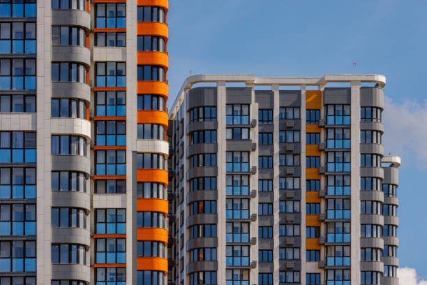 istock freshly built high rise apartment buildings on blue sky background with white clouds 1830576679