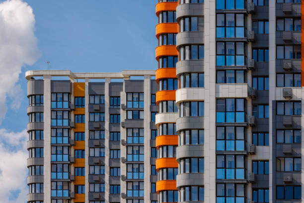 istock freshly built high rise apartment buildings on blue sky background with white clouds 1830576680