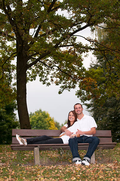istock young couple sitting on a park bench 183057725