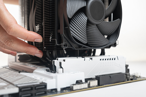 Installing a large air cooler on a computer processor.