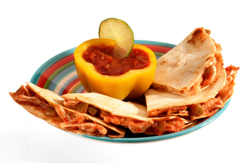 Chicken Quesadillas with salsa in yellow bell pepper bowl.  Served on festive plate.  Isolated on white.  Path included.