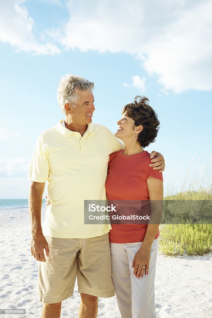 Loving couple mature avec les bras autour de se tenir sur la plage - Photo de Adulte libre de droits