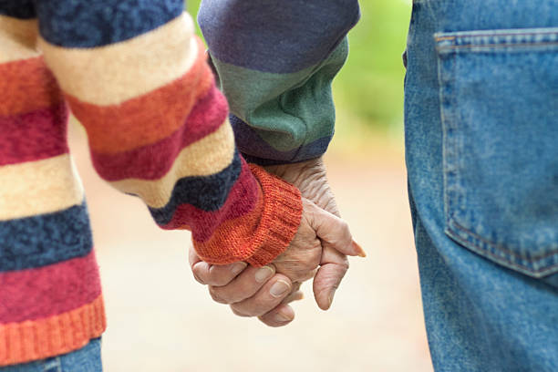 istock Seniors holding hands closeup - horizontal 183059076