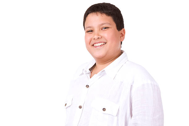 Casual adolescent boy smiling against white background stock photo